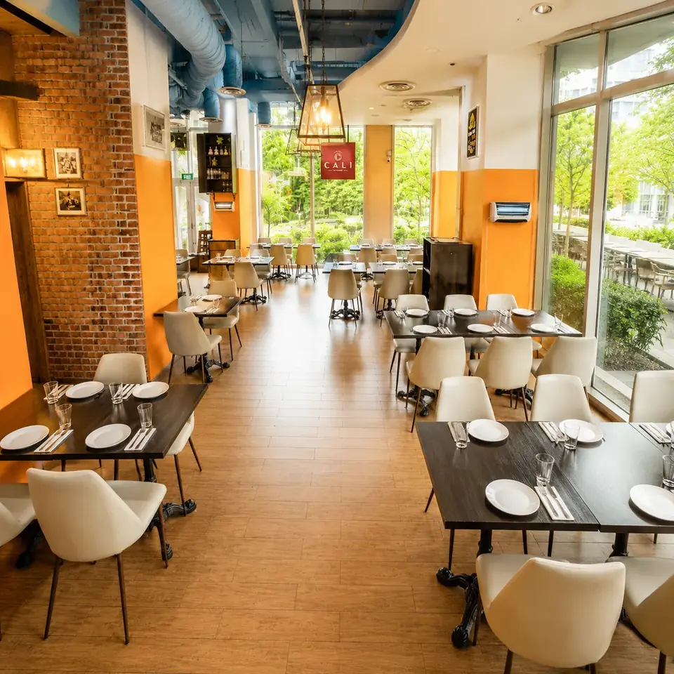 The bright brick-and-orange dining room at CALI Rochester Park